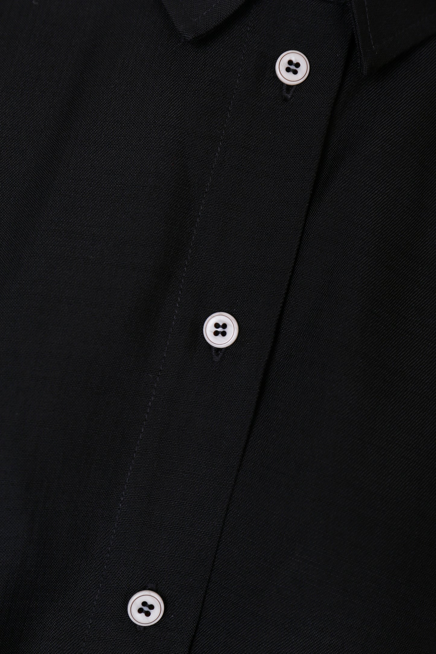 Close-up of the Japanese viscose fabric and white contrast buttons on the YIBRI Black Button-Up Shirt.