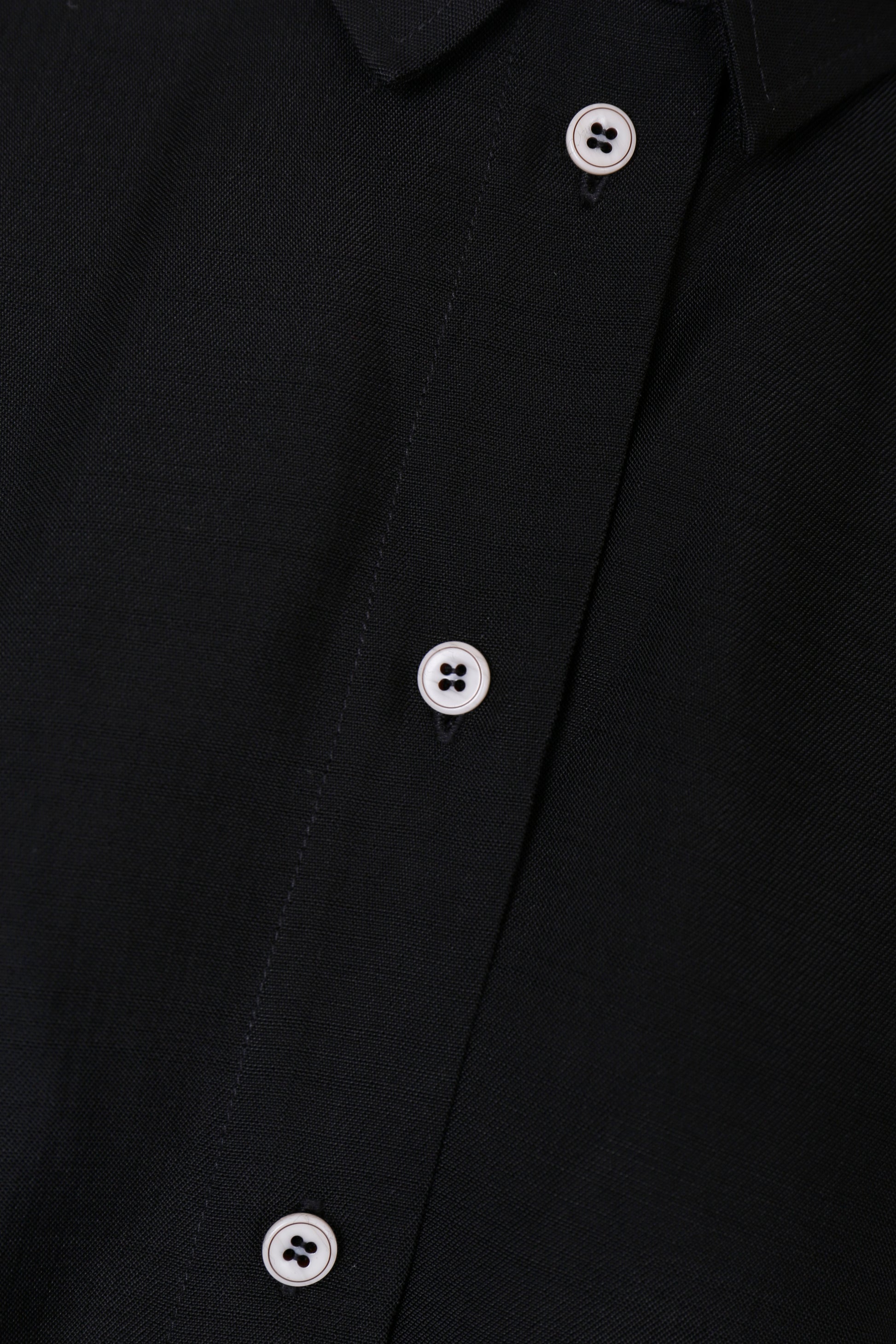Close-up of the Japanese viscose fabric and white contrast buttons on the YIBRI Black Button-Up Shirt.