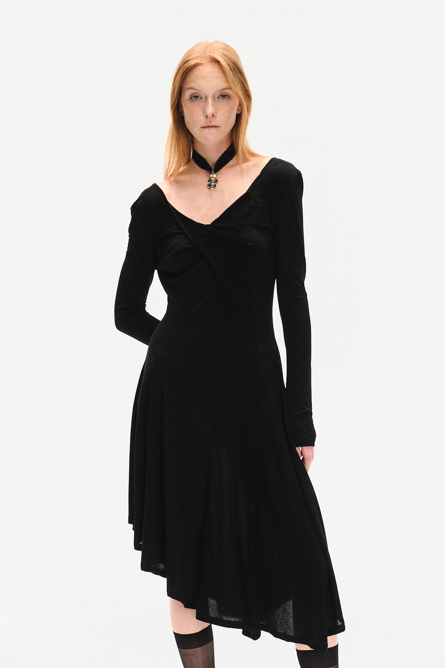 Close view of YIBRI black long sleeve fitted knit dress on model, highlighting twisted neckline, fluid knit movement and understated quiet luxury design