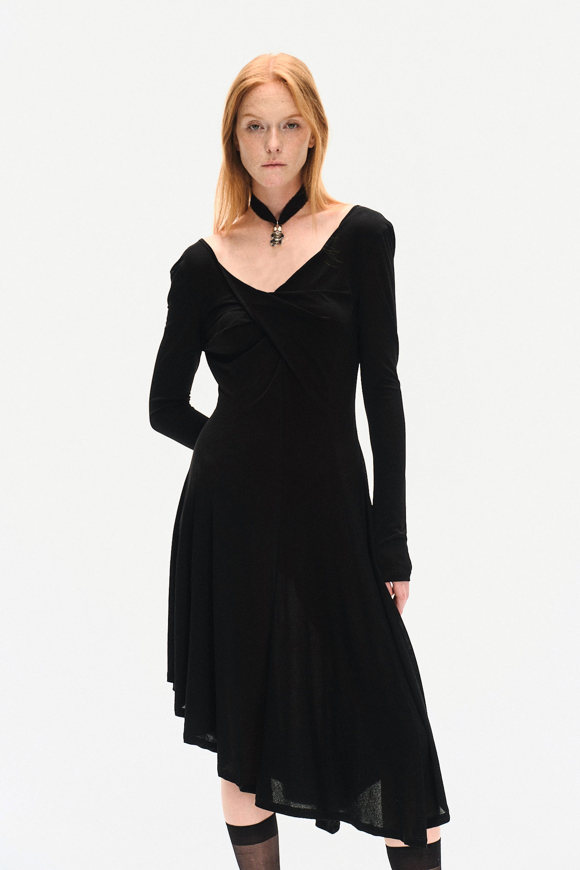Close view of YIBRI black long sleeve fitted knit dress on model, highlighting twisted neckline, fluid knit movement and understated quiet luxury design
