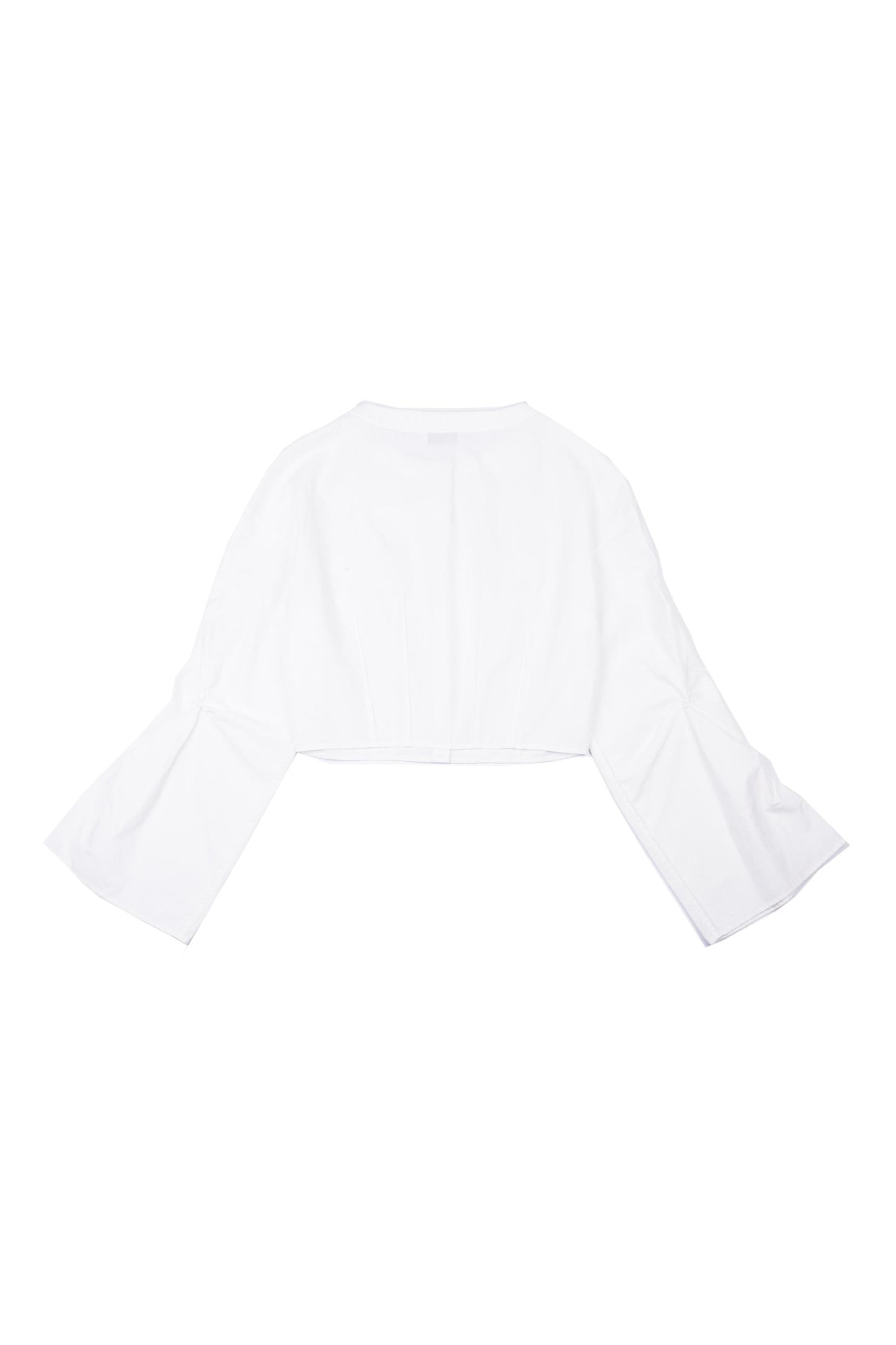 Back view of YIBRI cropped white cotton blouse showing clean panel lines, airy construction and soft drape through the sleeves.