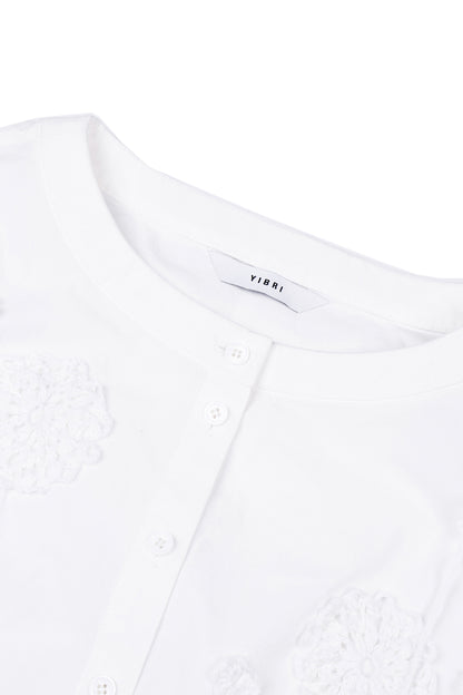 Close-up of the round neckline on the YIBRI cropped blouse, showing the crisp cotton poplin and refined buttoned placket.