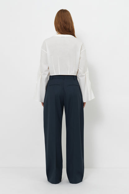Back view of model wearing the YIBRI cropped white blouse, revealing clean back panels and the slightly boxy cropped fit.