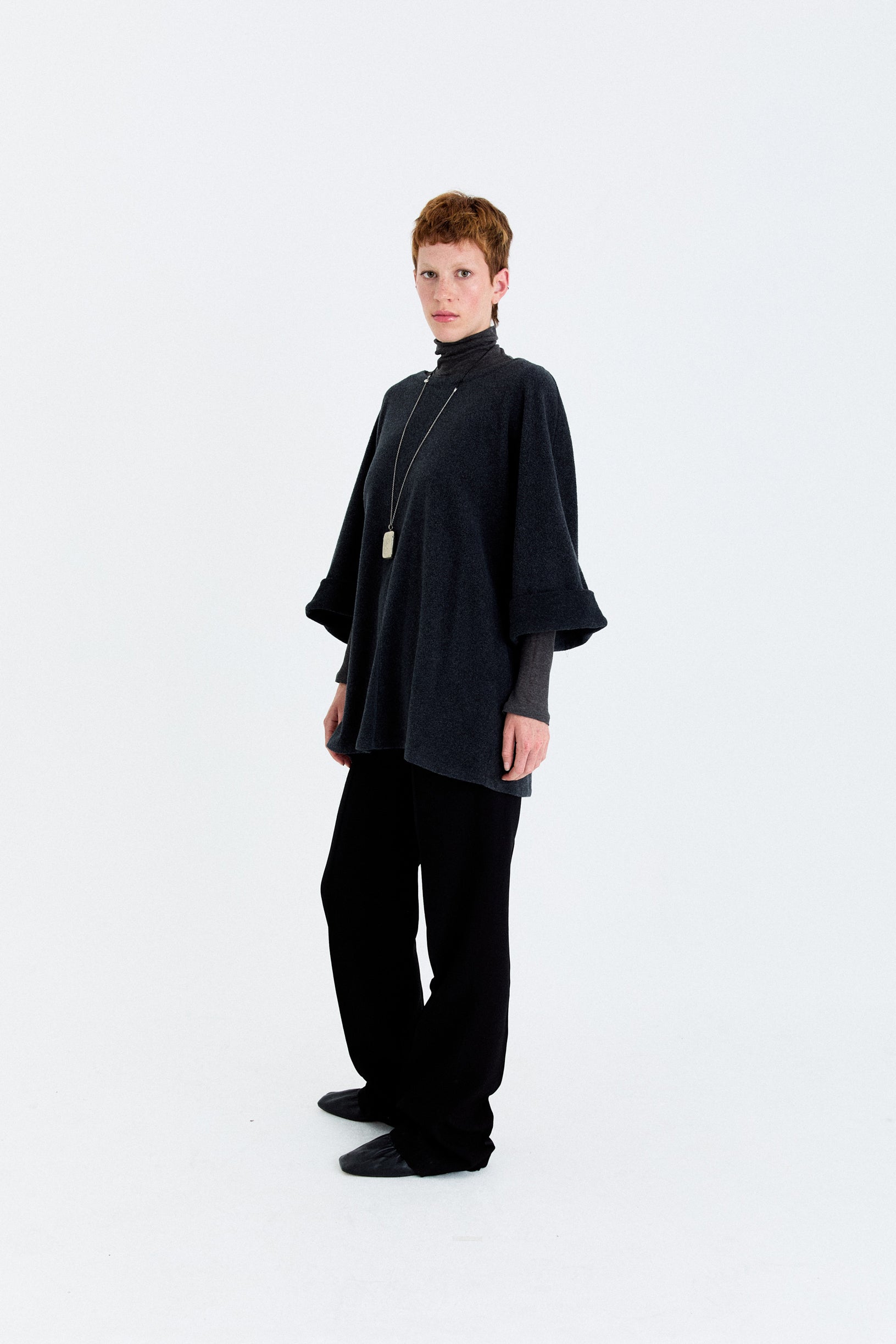 Model angled view in the YIBRI Fleece Oversized Roll-Sleeve Top in charcoal, showing the wide sleeves and soft, fluid drape.