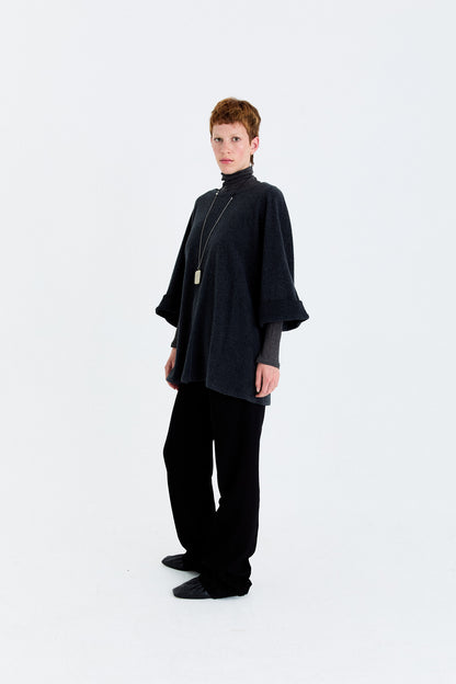 Model angled view in the YIBRI Fleece Oversized Roll-Sleeve Top in charcoal, showing the wide sleeves and soft, fluid drape.