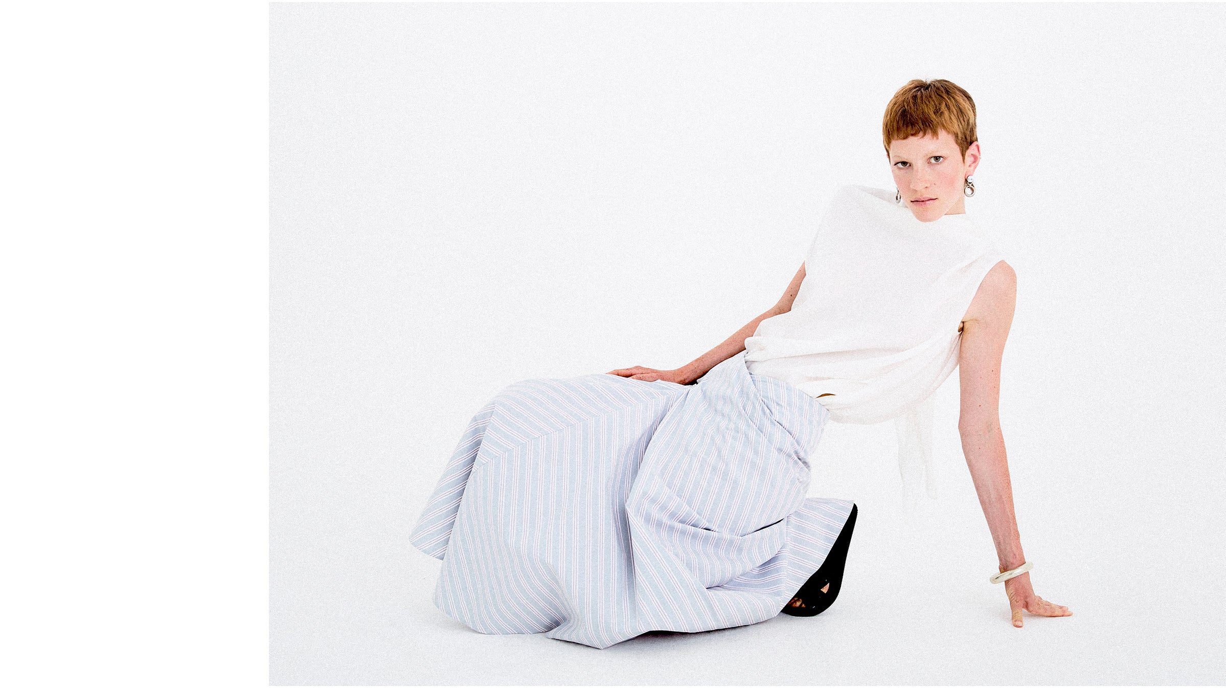 Person sitting on a large bean bag chair against a white background