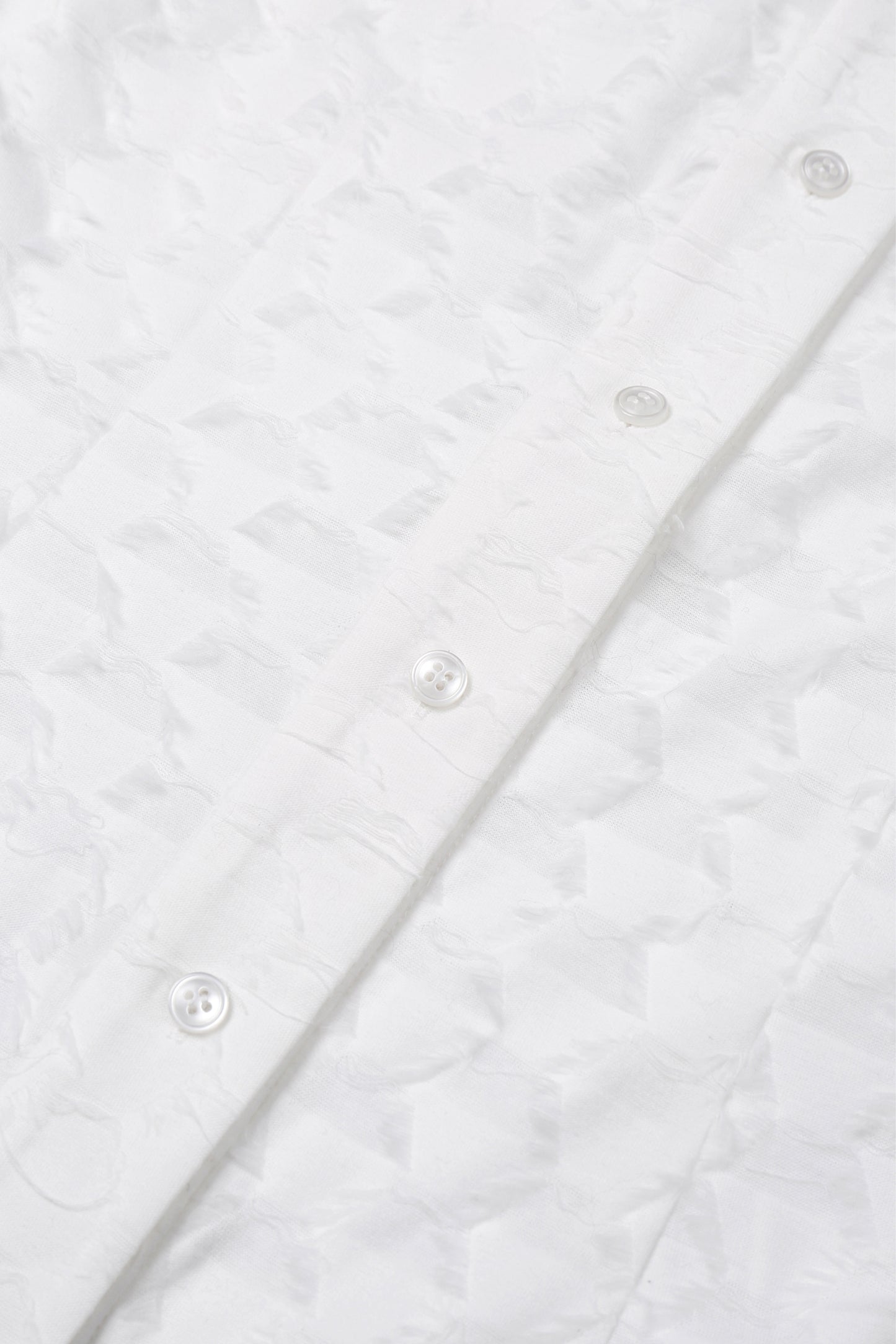 Detail of the button placket on the YIBRI Jacquard Fringe Shirt, highlighting tonal buttons and the dimensional woven texture.