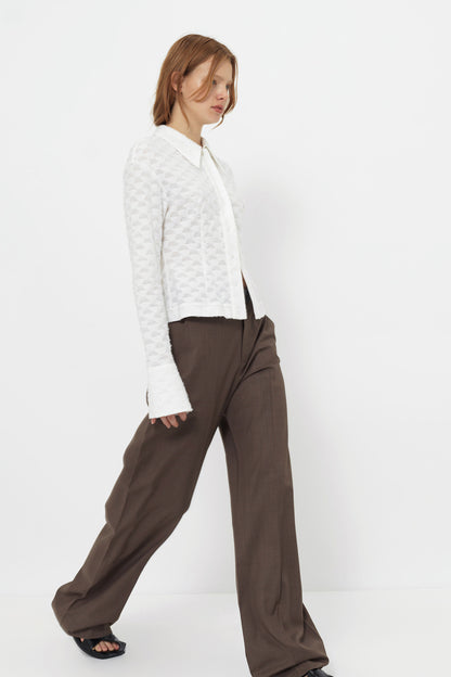 Side view of the YIBRI Jacquard Fringe Shirt on model, highlighting sleeve flare, pointed collar, and geometric jacquard texture.