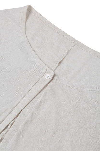 Close-up of the neckline and button fastening on the YIBRI Reversible Cropped Cardigan, showing the fine textured jersey and subtle top stitching.