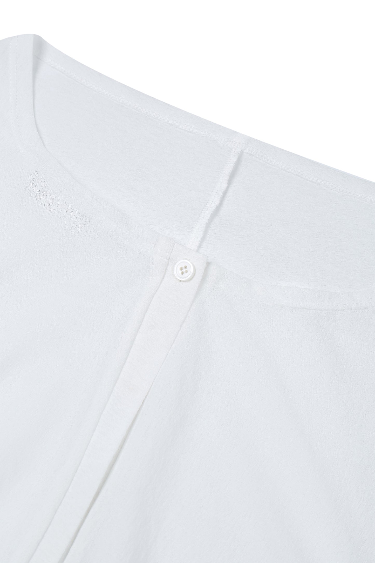 Close-up of the neckline on the YIBRI Reversible Cropped Cardigan highlighting soft jersey texture and refined stitching.