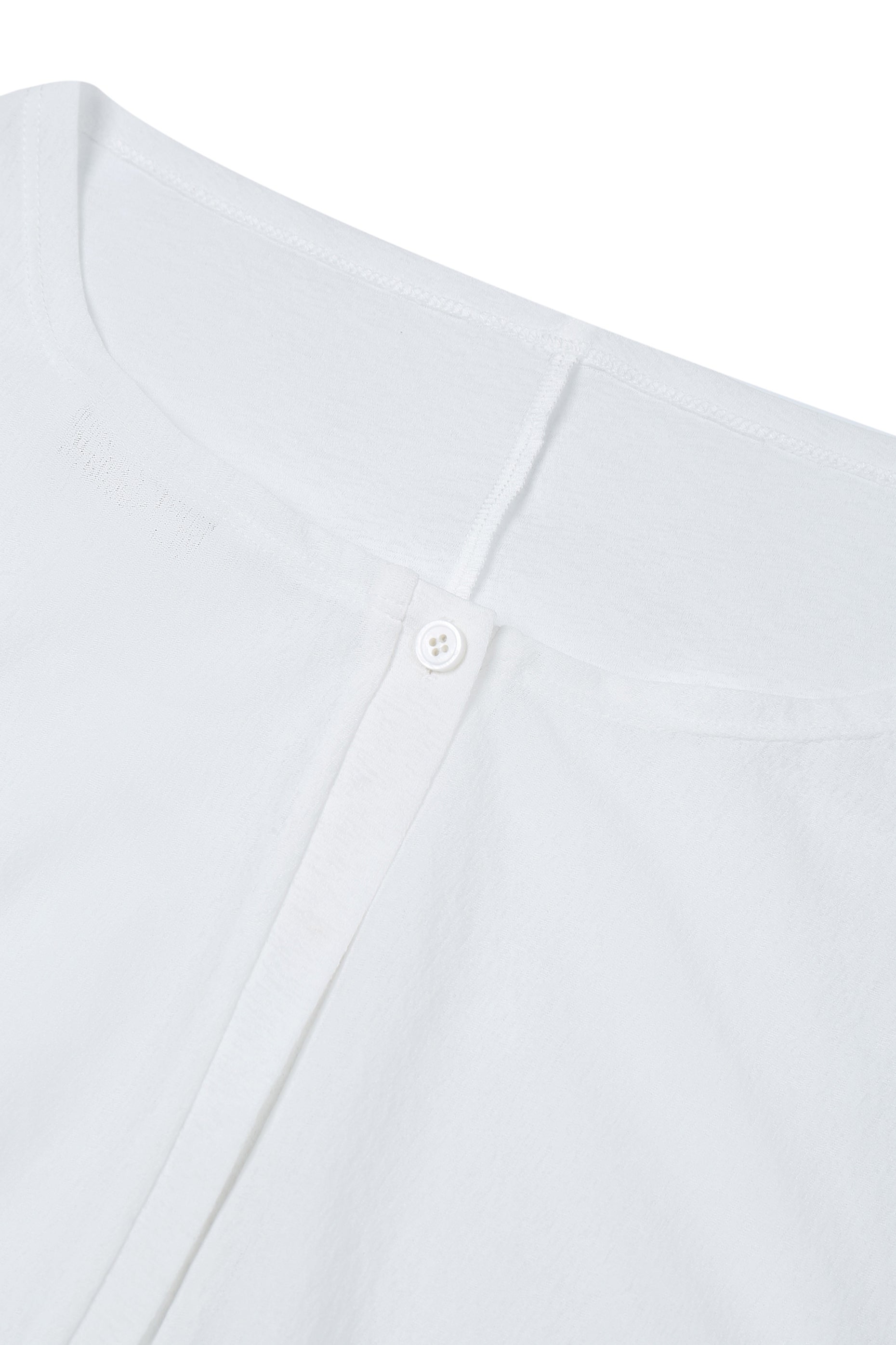 Close-up of the neckline on the YIBRI Reversible Cropped Cardigan highlighting soft jersey texture and refined stitching.