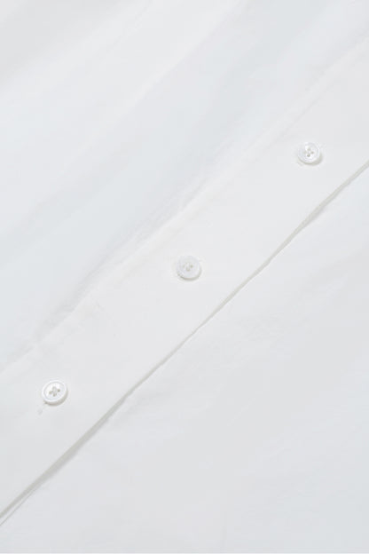 Close-up of white washed cotton fabric and button details on the YIBRI Ruched Collar Long Shirt, highlighting natural fibre texture and refined craftsmanship.