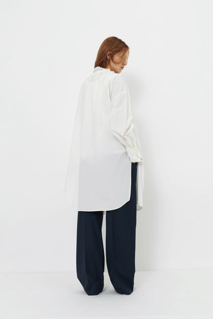 Back angle of model wearing the YIBRI Ruched Collar Long Shirt in white washed cotton, featuring natural fibre texture and soft quiet luxury movement.