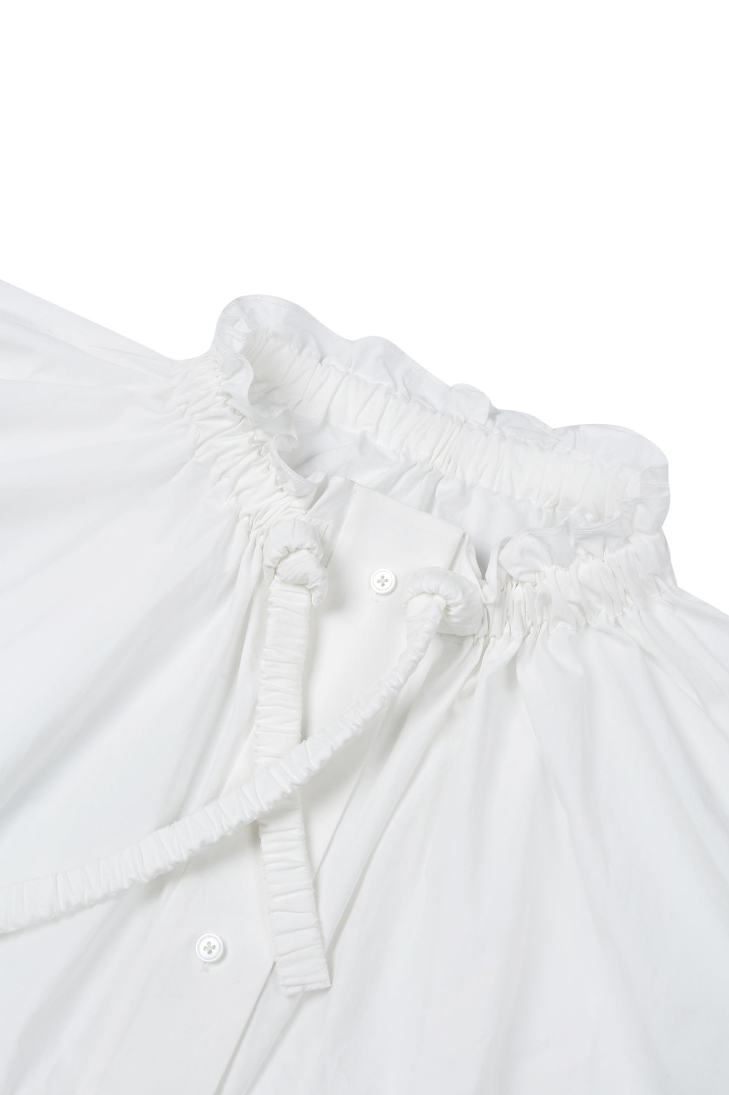 Close-up of white washed cotton fabric and button details on the YIBRI Ruched Collar Short Shirt, highlighting natural fibre texture and refined craftsmanship.