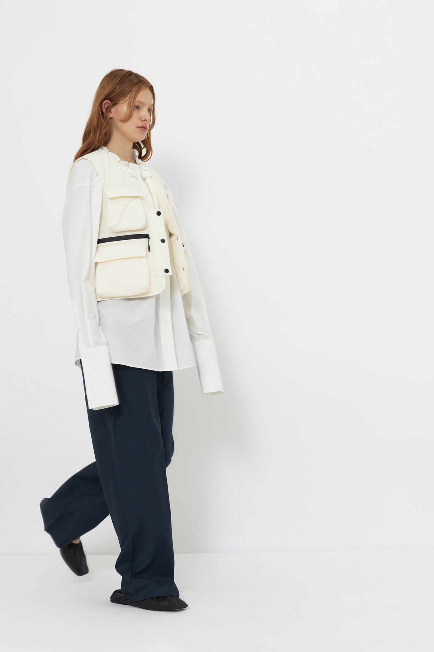 Model wearing the YIBRI Ruched Collar Short Shirt in white washed cotton layered over trousers — oversized quiet luxury silhouette with sustainable natural cotton fabric.