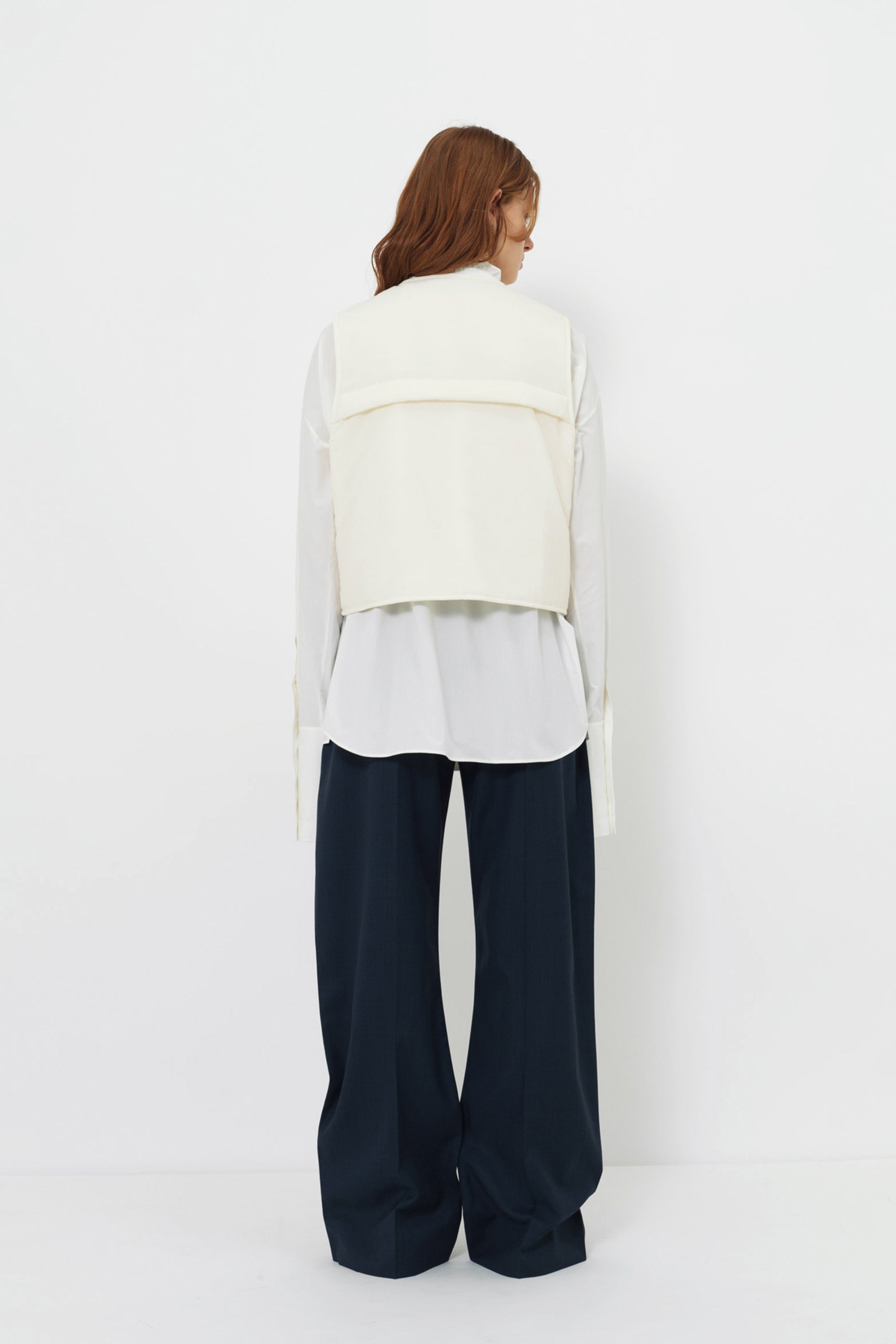 Back angle of model wearing the YIBRI Ruched Collar Short Shirt in white washed cotton, featuring natural fibre texture and soft quiet luxury movement.