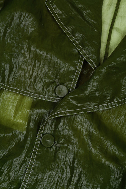 Close-up of a green sheer trench coat with buttons, made from nylon fabric 