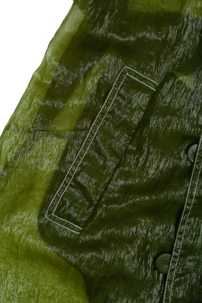 Close-up of a green nylon trench with white contrasting stitching details.