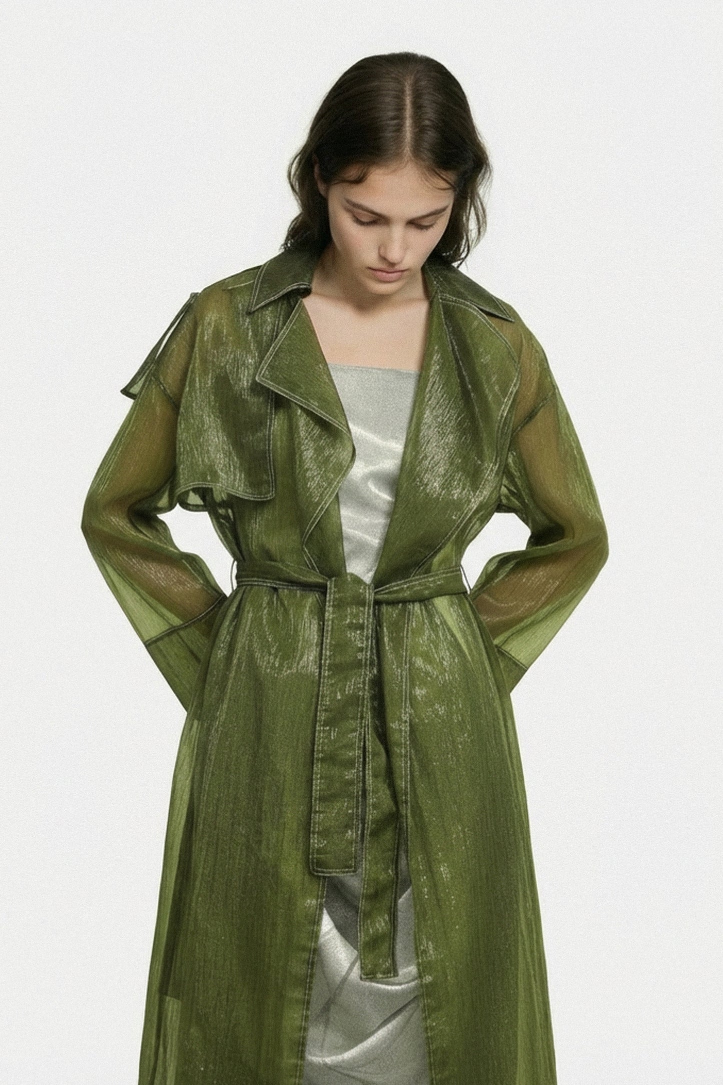 Woman wearing a green trench coat on a white background