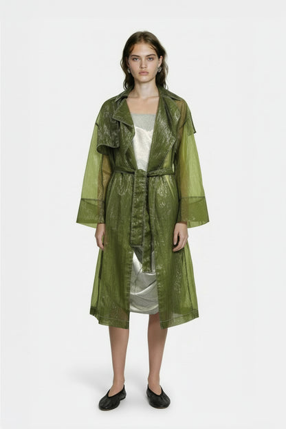 Woman wearing a green trench coat over a white dress on a white background, by independent designer YIBRI