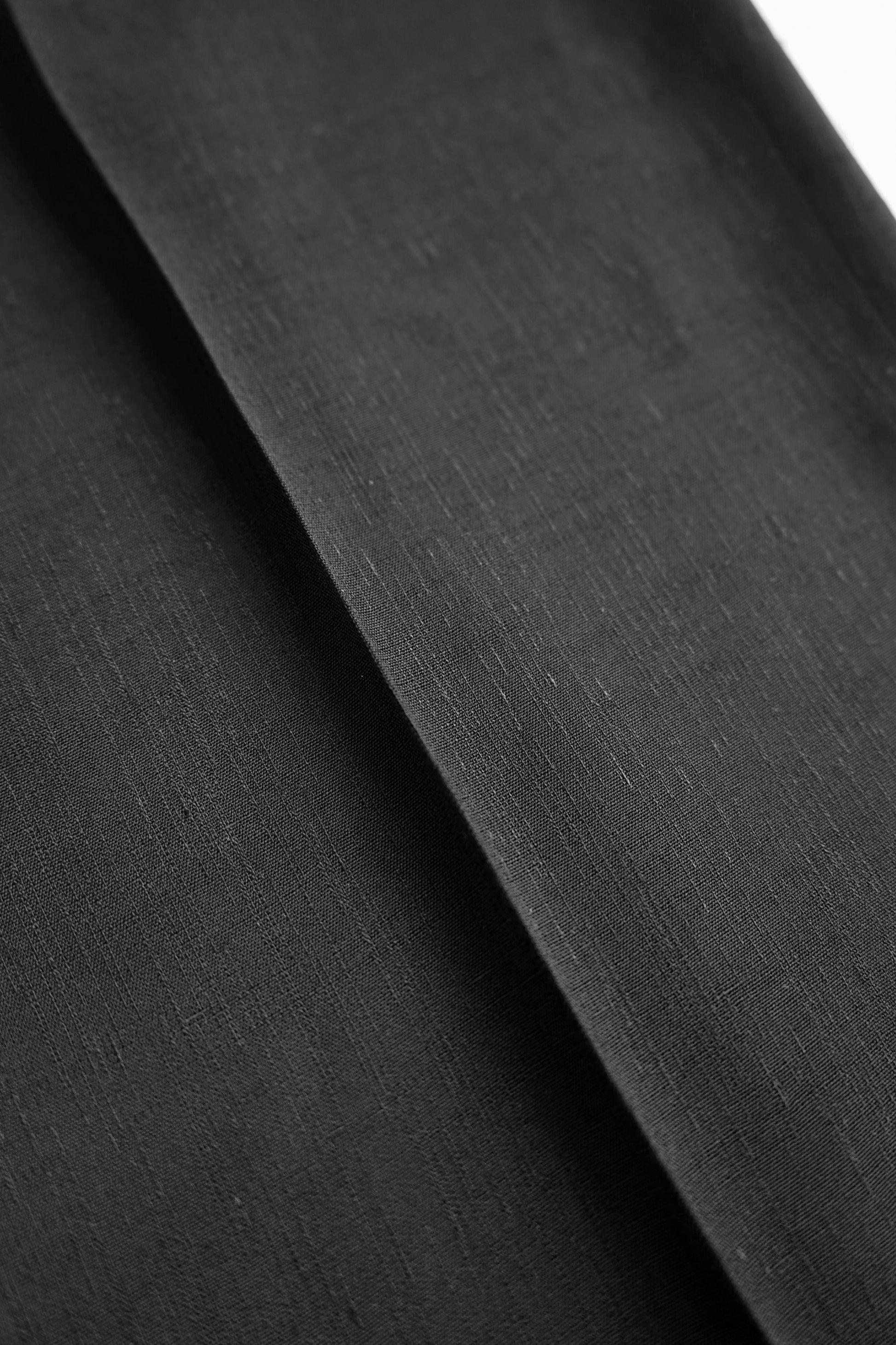 Close-up of the black suiting fabric used in the YIBRI Straight-Leg Suit Trousers, highlighting its subtle texture and premium weave.