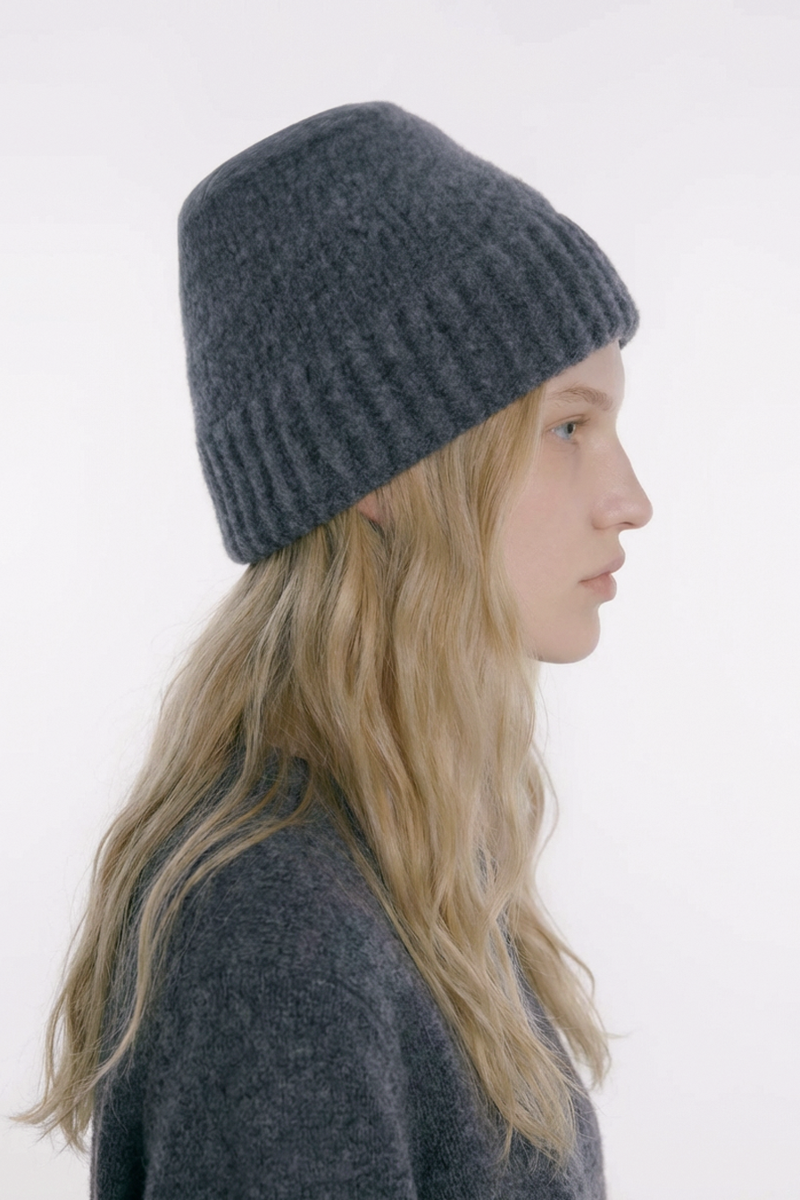 female model wearing a gray knit beanie against a white background, Independent London designer travel  Italian wool bucket hat.