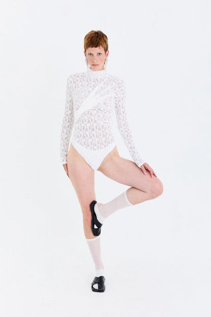 Detail view of the twisted front drape on the YIBRI Reversible Twisted-Knot Top in black lace, highlighting sculpted gathering and delicate sheer texture.