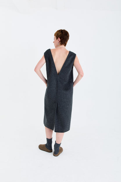 Person wearing a dark gray double face wool dress with a deep V-neck on a white background