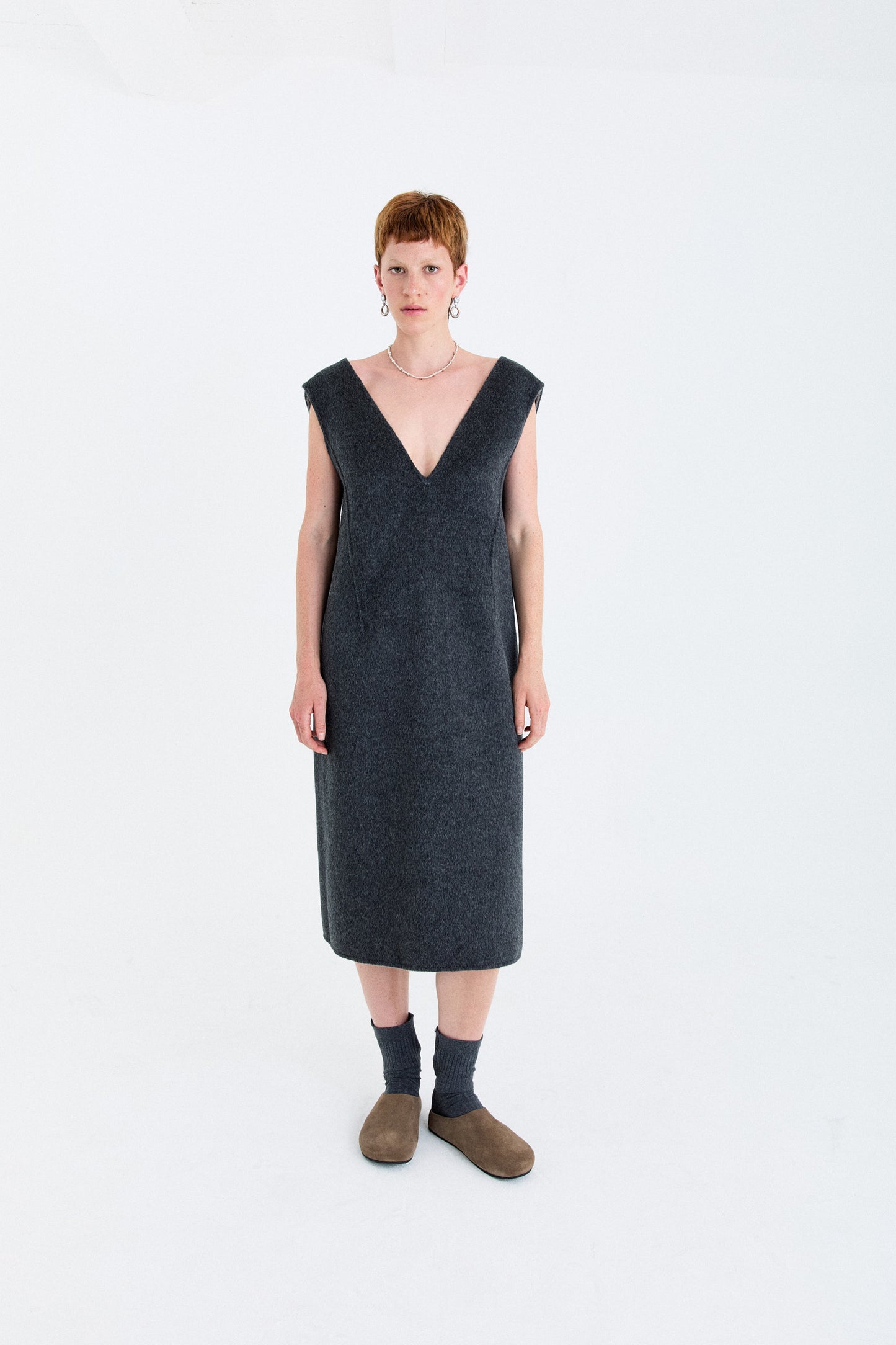 Woman wearing a dark gray dress on a white background