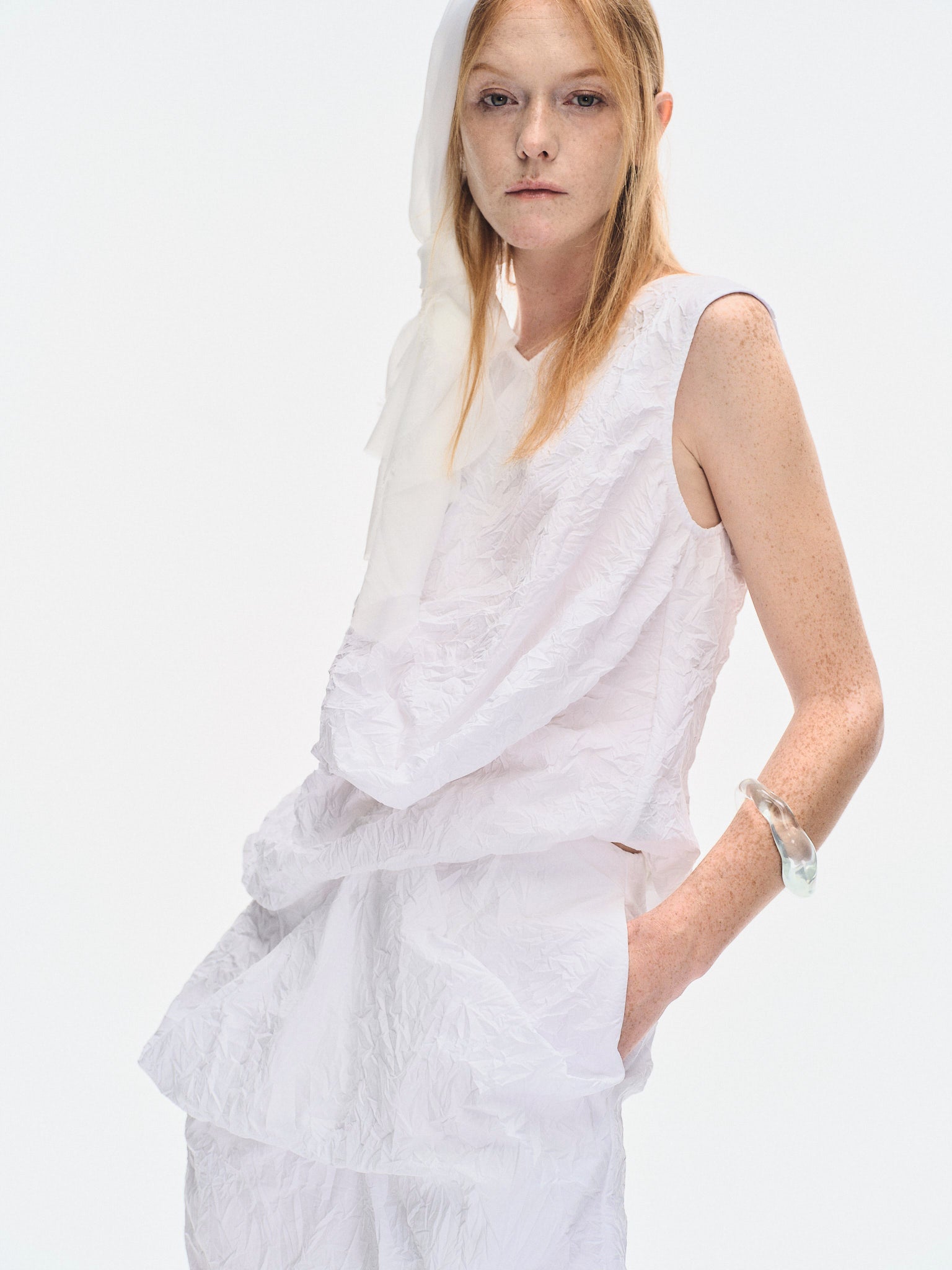 Close-up of the YIBRI White Crinkled Texture Sleeveless Top on model, capturing the textured crushed fabric and soft sculptural front fold.