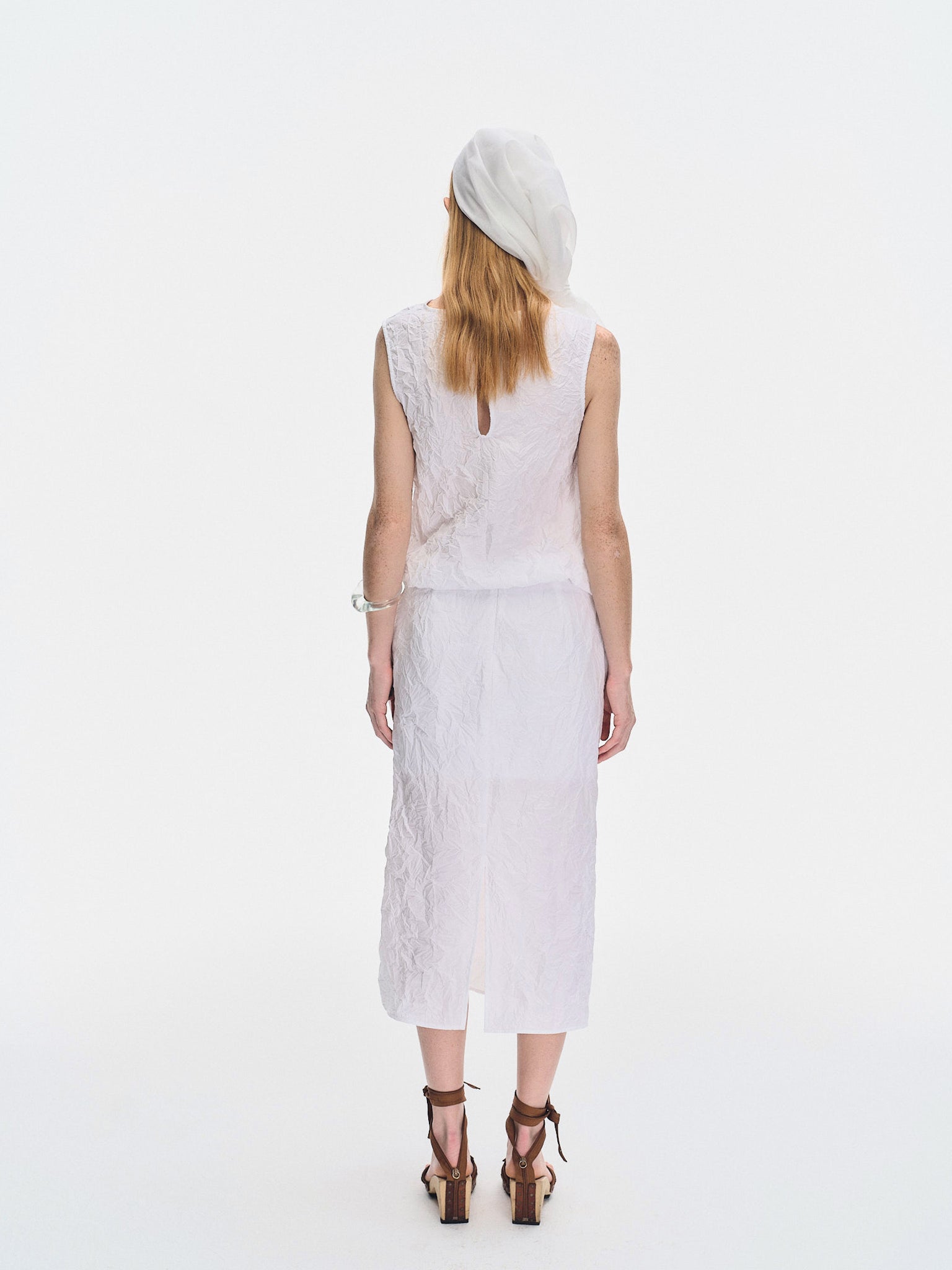 Back view of model wearing the YIBRI White Crinkled Texture Sleeveless Top, showing the clean minimal back panel and keyhole detail.
