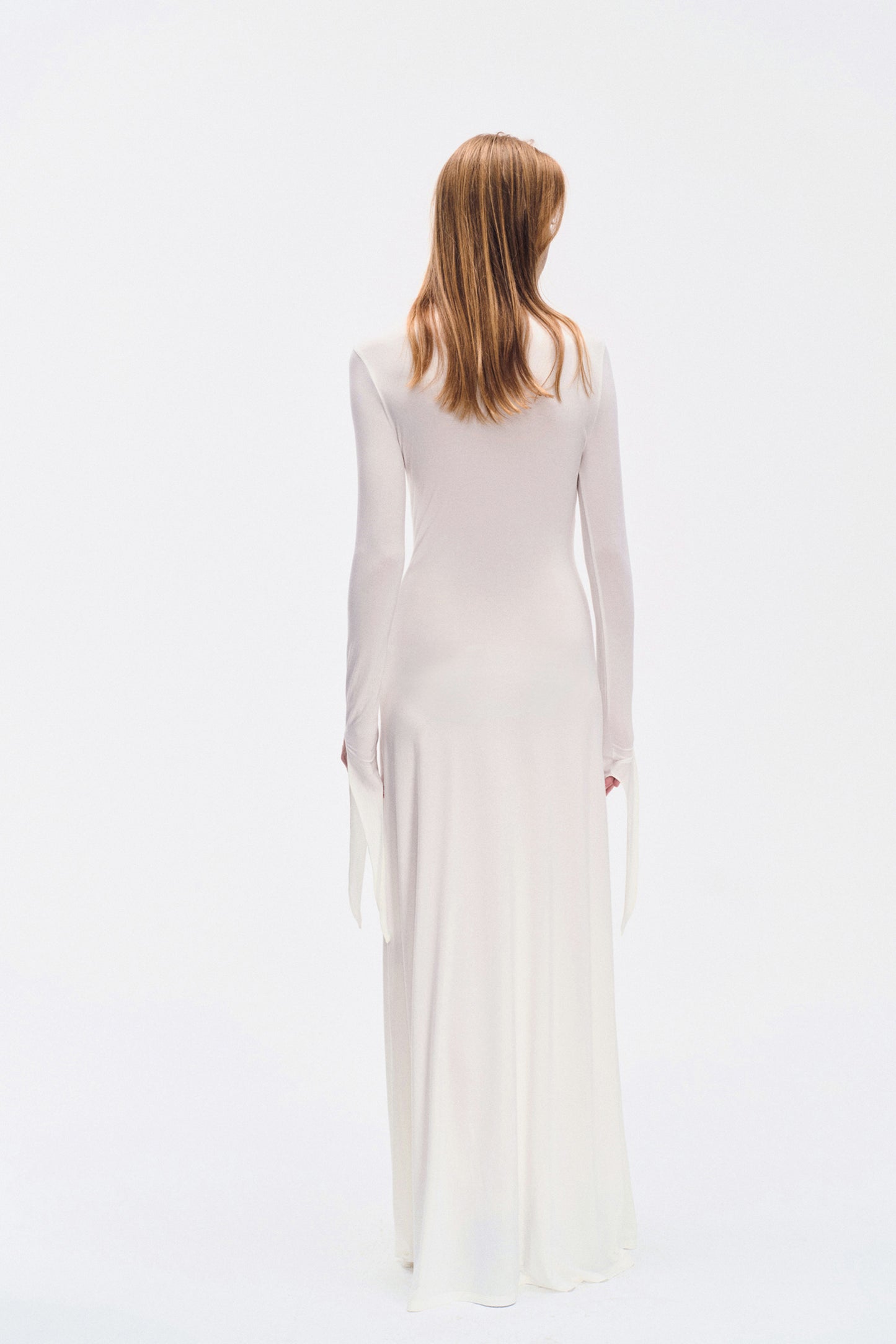 Back view of YIBRI ivory draped long-sleeve maxi dress showing clean minimal silhouette and extended cuff ties