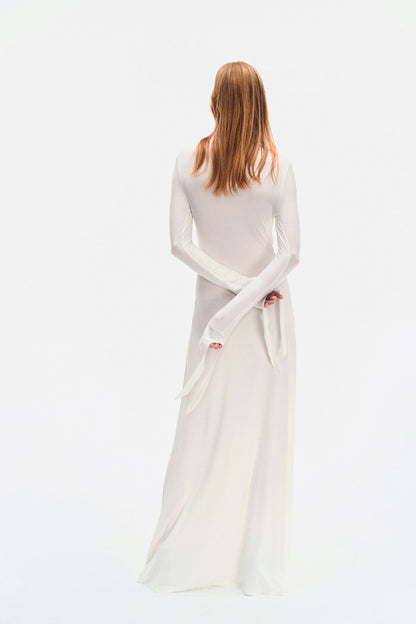 Rear angle of YIBRI ivory maxi dress with long sleeves, extended cuff ties and fluid full-length skirt.
