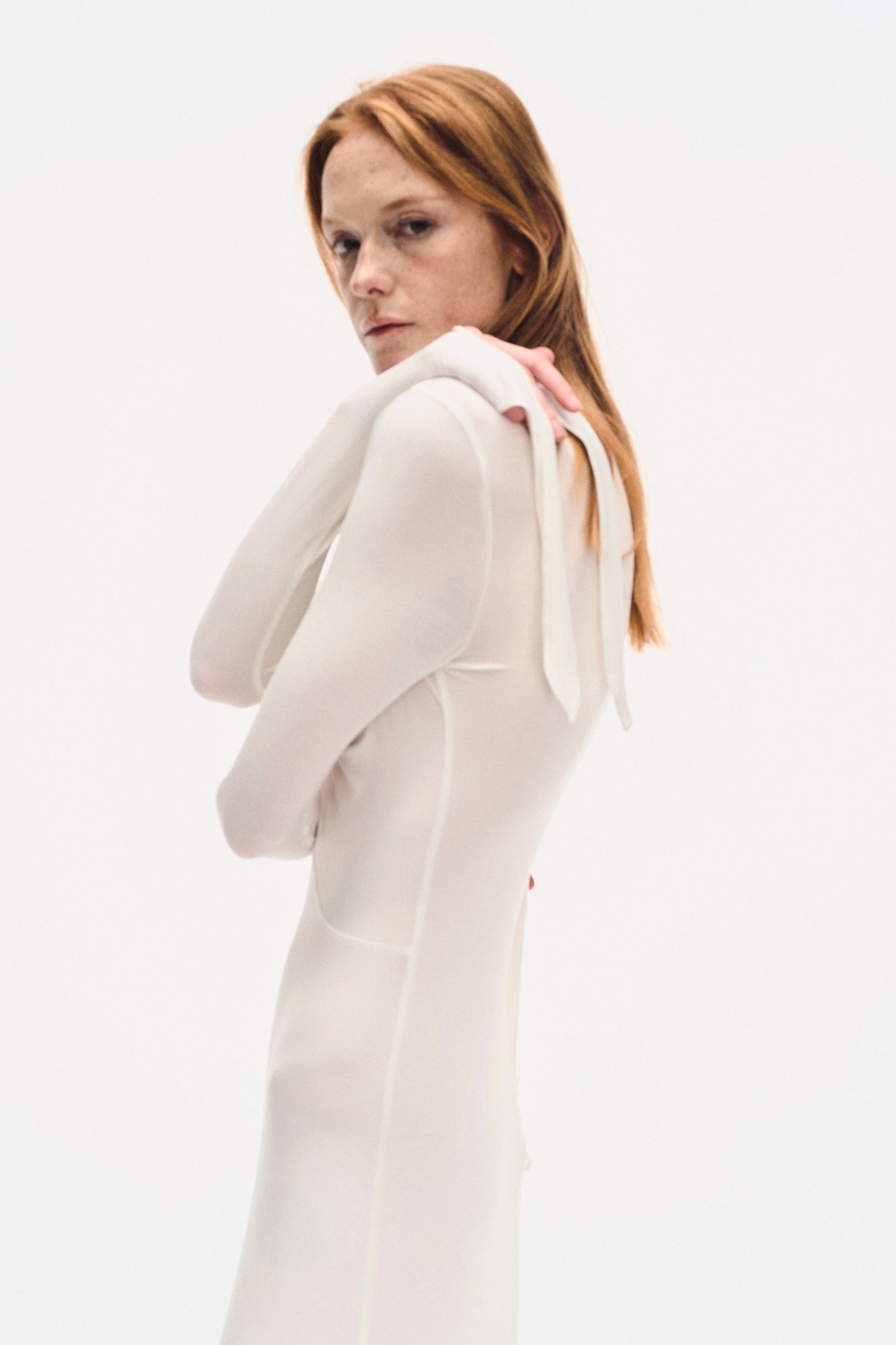 Close-up side view of YIBRI ivory draped jersey maxi dress highlighting seam lines, soft stretch fabric and extended cuff details