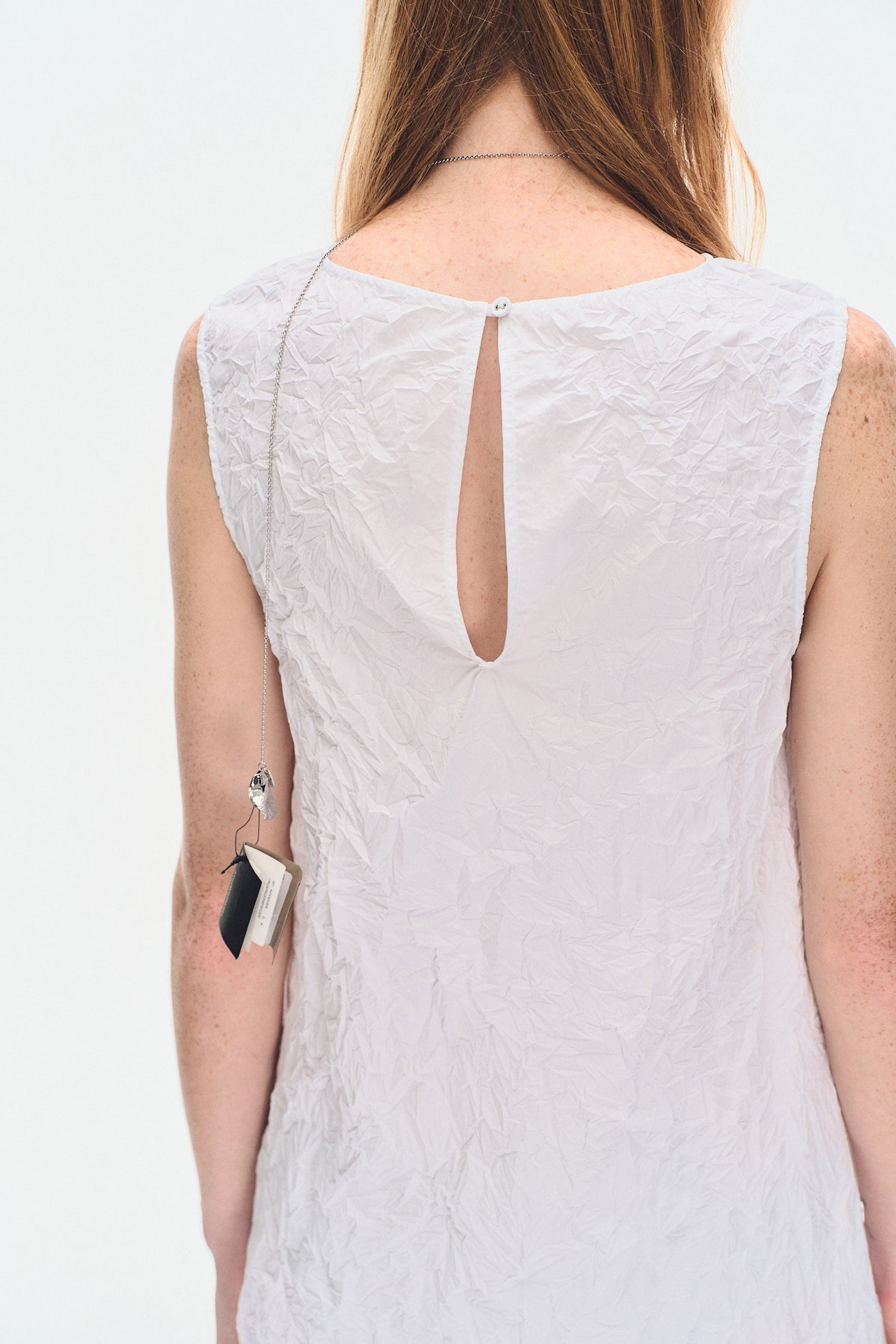 Back close-up of YIBRI White Sculpted Crinkle Mini Dress displaying keyhole fastening and textured crinkle fabric with clean minimal construction.