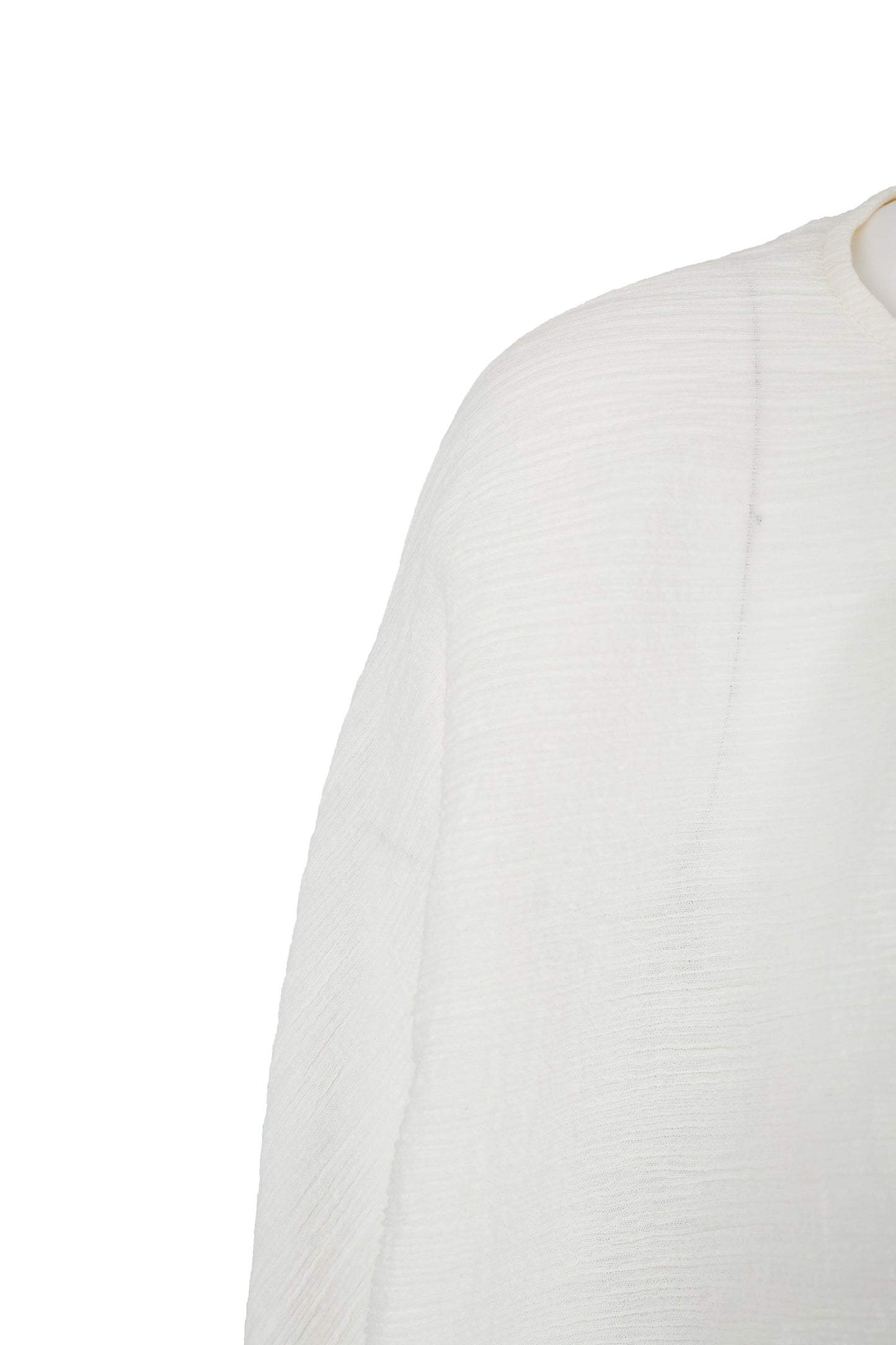 Close-up of the wrinkle-textured fabric on the YIBRI Reversible Top, highlighting the lightweight semi-sheer surface and subtle grain.