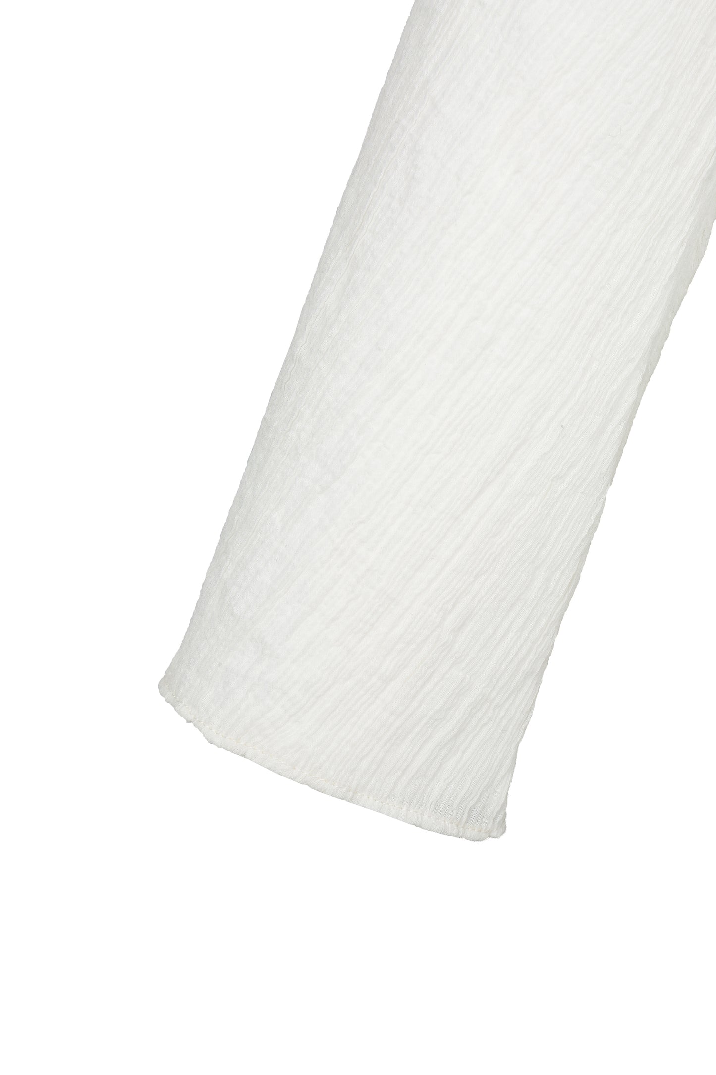 Close-up of the sleeve hem of the YIBRI White Wrinkle-Textured Reversible Top, showing lightweight drape and soft textured weave.