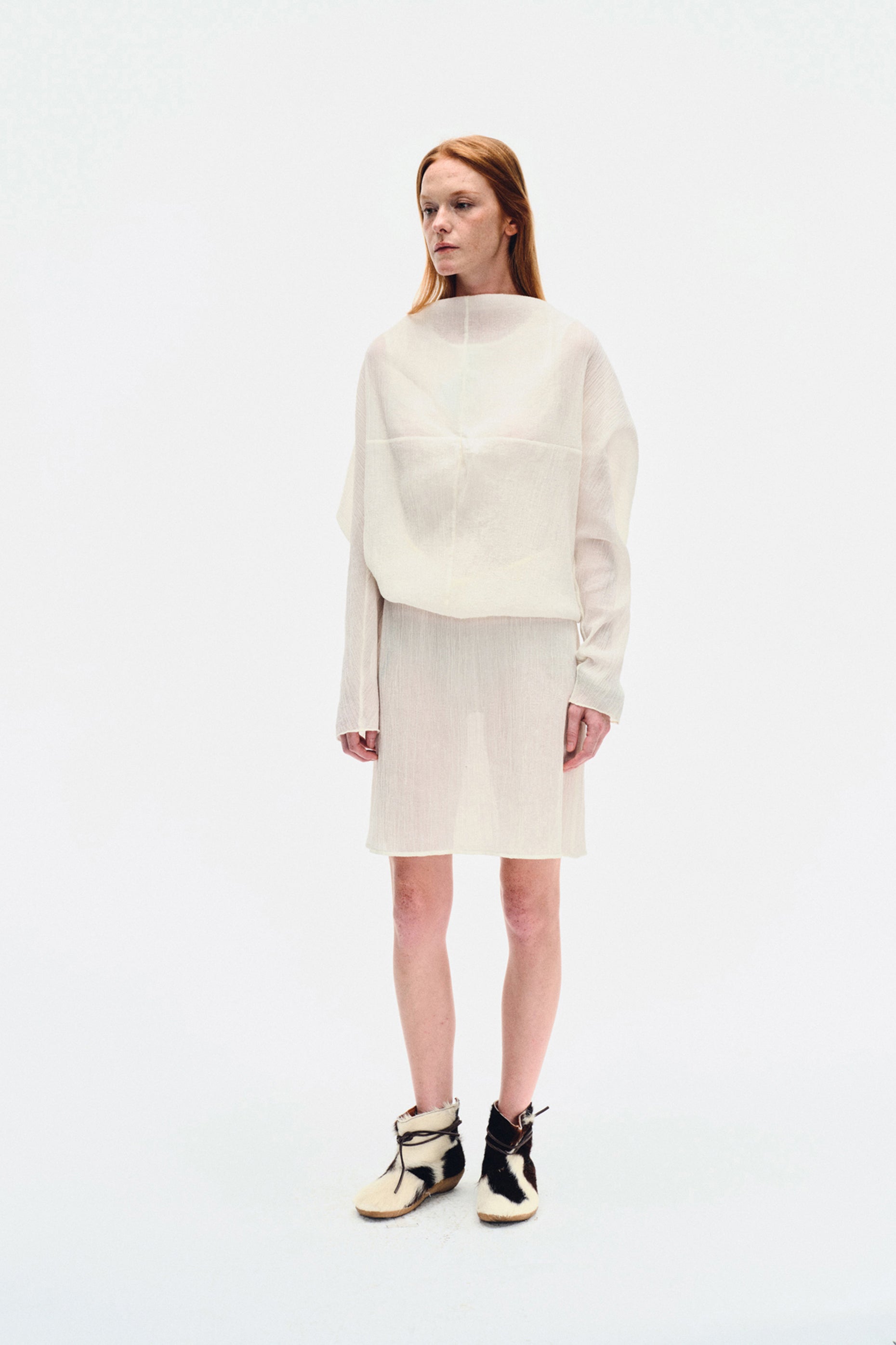 Side view of model wearing the YIBRI White Wrinkle-Textured Reversible Top, highlighting the draped batwing sleeve and relaxed fit.