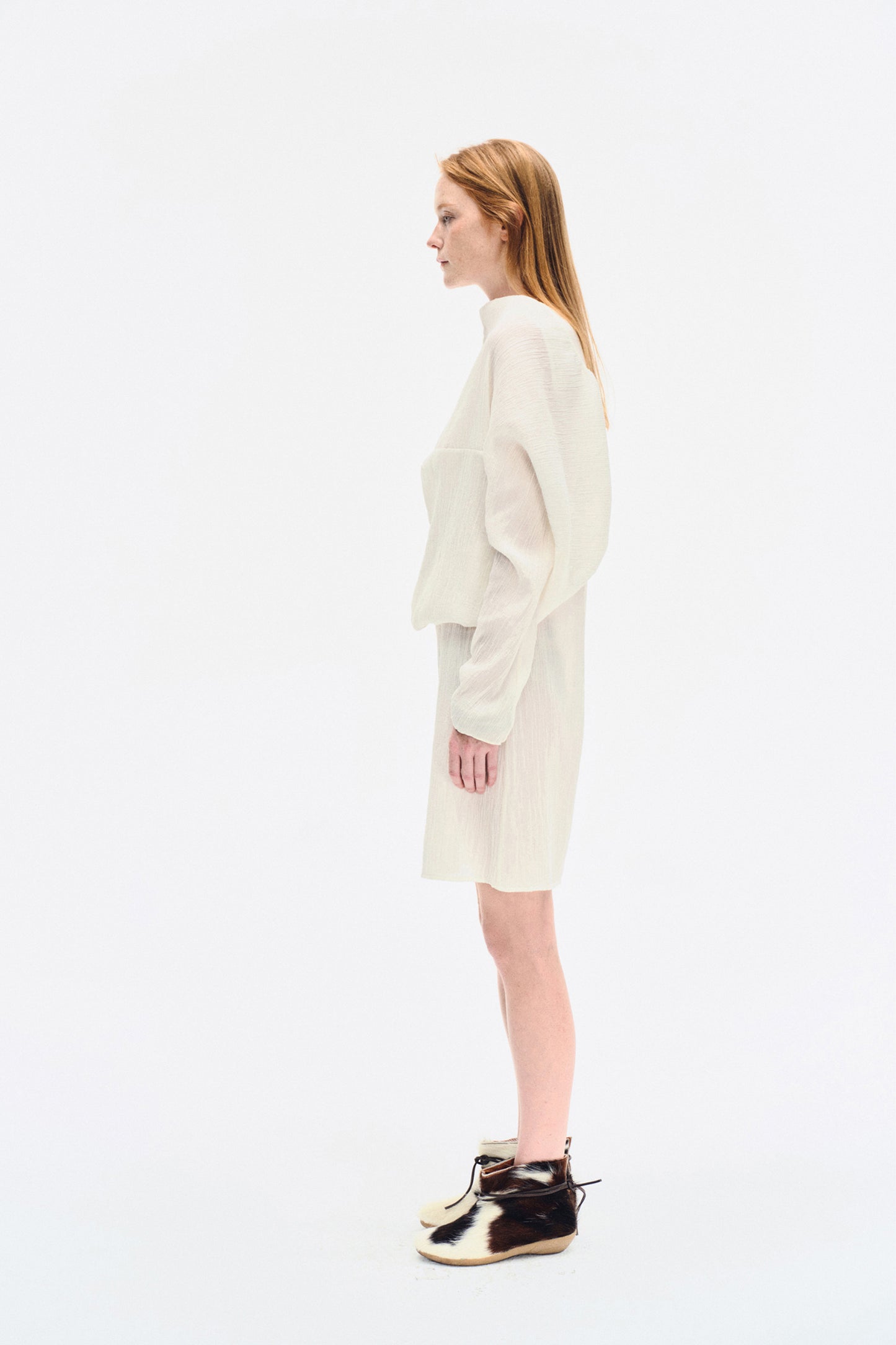 Angled front view of the YIBRI White Wrinkle-Textured Reversible Top, showing the soft volume and architectural shape.