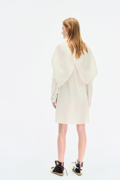 Back view of the model wearing the YIBRI White Wrinkle-Textured Reversible Top, featuring the sculptural reverse panel and gentle folded shape.