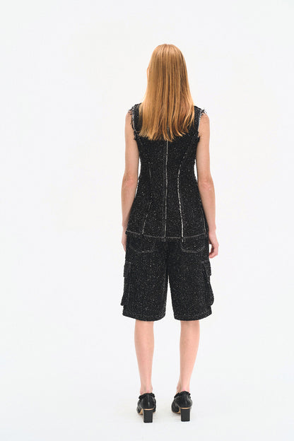 Person wearing a black sleeveless dress with a white background