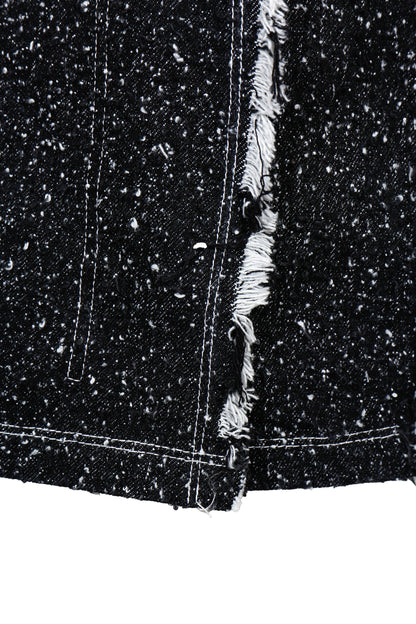 Close-up of a black denim fabric with frayed edge on a white background