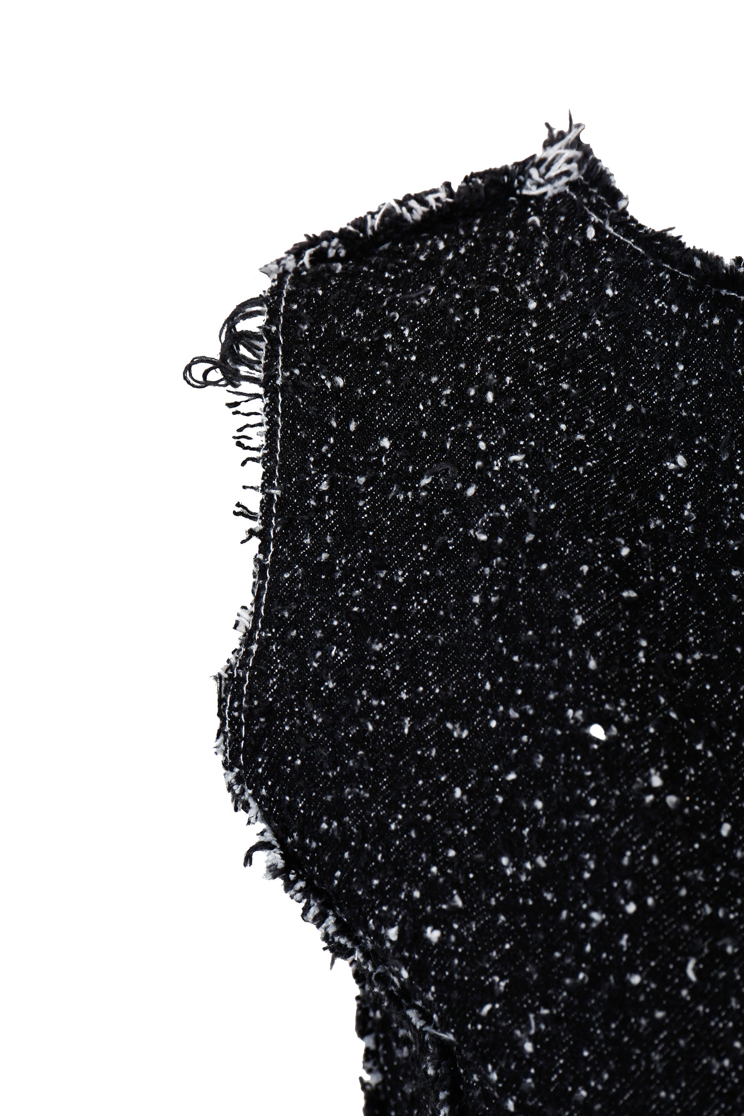 Close-up of black textured fabric with frayed edge on a white background